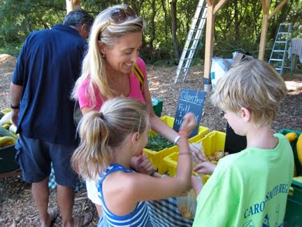 Lorrie with her children picking treasures at the farmers market. It's a great idea to bring your children along and have them help choose what you're going to eat for dinner.