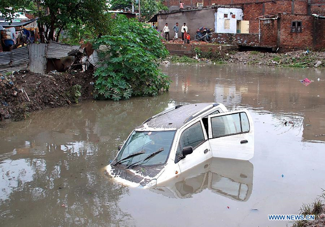 A car is submerged in water in the low-lying area after the heavy rains in Indore, Madhya Pradesh state, India, 4 July 2013. Heavy rains in the city caused flood in the low-lying area, disrupting traffic and normal life. Photo: Xinhua / Stringer