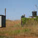 The outhouse (students should consider themselves lucky when they have one) and water storage tank. Water for this homestead comes from a nearby homestead up the hill; there's no piped supply around the area so I believe it's hauled or they hire a water truck.