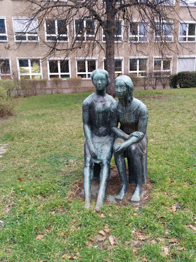 Statuen 2 Mädchen auf der Bank