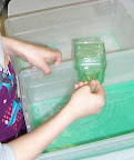 child scooping colored water