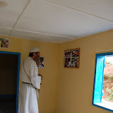  &ndash; Father investigates pictures of dear friends and family posted on wall of office..© 2008 September Nazareth House Apostolate Media, James B. Mansaray, photographer.