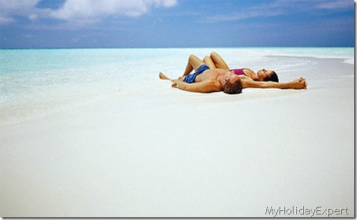 couple-sunbathing-on-tropical-beach