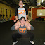 Forget the olympic bar.  Squat your friend!