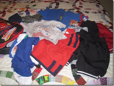 A bed full of clothes that Austin had packed A bed full of clothes that Austin had packed