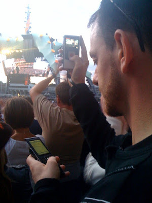 Holding a flip camera in one hand recording the U2 concert in Croke Park and tweeting from a mobile phone in the other