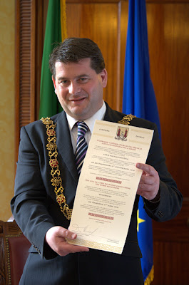 Cork's Lord Mayor Dara Murphy holding a decree scroll