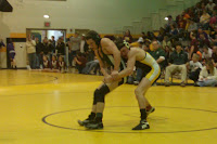 Pella Brent Smith and Knoxville's Aaron Crossett battle during a match at the District Saturday in Knoxville.  Smtih Would later qualify for the state meet.