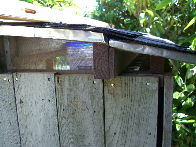 Cedar fencing on. Old metal screen doors to keep critters out. Coke cans used as flashing.