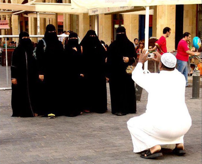 This undated photograph shows that an Arabian person is taking photographs of his five female family members during a trip.