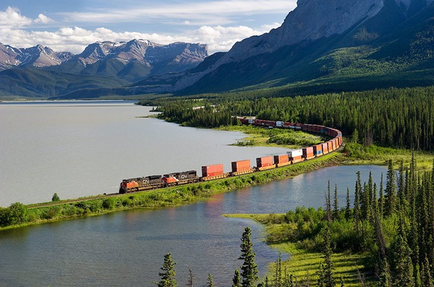 Train swings through a curve along Brule Lake with the Miette and Brule ranges providing the back drop.