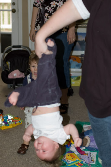 Sam being held by her leg, upside down...