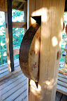 This is a Buddhist prayer wheel up in a treehouse of a structure.