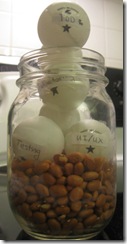 Canning jar, bottom half filled with kidney beans but over full with ping-pong balls