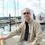 Skipper Tom at the helm, wearing his favorite sailing shirt, which is now almost a rag!