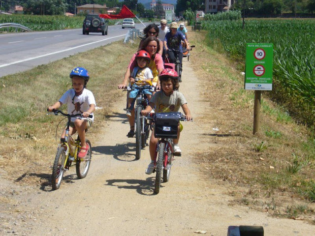 Ni&ntilde;os disfrutando de un paseo en bici con sus padres
