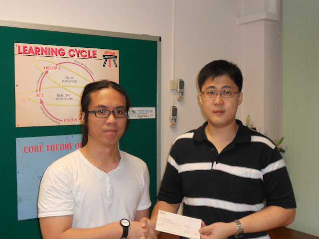 Ng Hong Kiang (left) receiving the Bursary Award from AJCAA President Lau Kiat Meng.