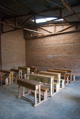 Empty classroom, with desks and brick wall