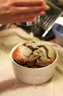 picture of final dark chocolate souffle being topped with confectioner's sugar