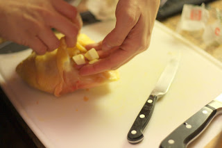 picture of butter being placed under skin of chicken breast