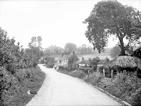 George and Dragon. Looking down the village lane from the railway bridge toward the inn, with Upton Lodge in the distance on the hill. Reproduced by permission of English Heritage NMR.