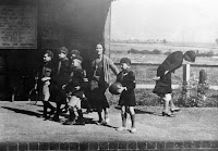 Mrs. Albert William Smith with the Upton &amp; Blewbury Cubs seeing them safely on their way to summer camp from Upton station. Approx 1934. Poster reads "Travel Cheaper Still in 1935"...