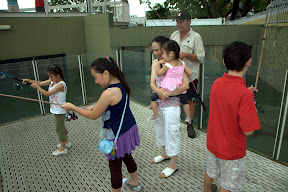 Tina and Ashley look on as Bianka and Cecilia feed the crocodiles
