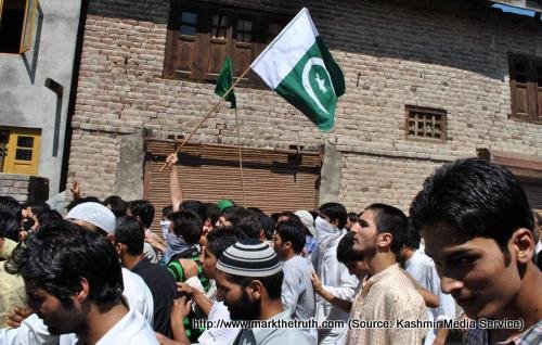 Kashmiris holding a Pakistani flag during a protest in Srinagar - Occupied Kashmi