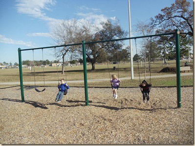 Travis, Heather and Jeffrey on the swings.