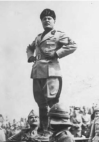 Benito Mussolini, in a characteristic braggadocio pose. 