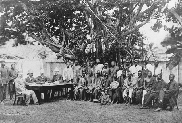 British Colonial Administrators Meet with Nigerian Representatives. During the colonial period in Africa, the British appointed African collaborators and gave them "warrants "" to act as local representatives of the British among their people. This meeting between British administrators and African representatives took place in Lagos, Nigeria, in the early twentieth century.