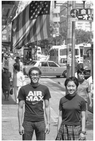 Japanese Locals in Okinawa. Two Japanese young people pose for a photograph on a busy street in Okinawa, Japan, on April 17, 1997. The long-standing presence of the U.S. military in Okinawa was responsible for the gradual Americanization of this Japanese island prefecture. 