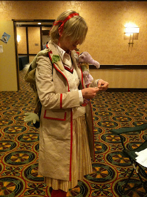 Young blonde woman in a Fifth Doctor variant costume.