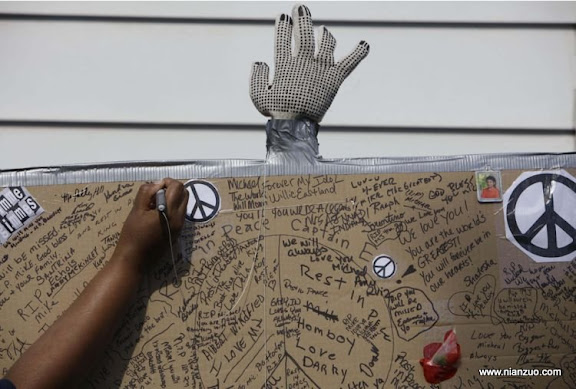 关于杰克逊 A mourner signs a condolence poster as people gather outside the boyhood home of pop star Michael Jackson Friday, June 26, 2009, in Gary, Ind. Jackson, 50, died Thursday of an apparent heart attack. (AP Photo/ M. Spencer Green)