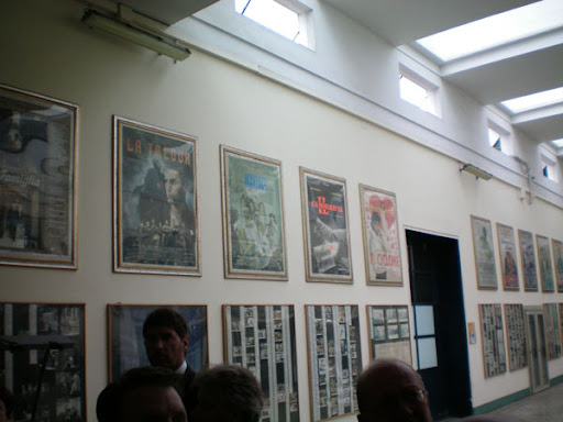 a group of people standing in front of a wall with posters