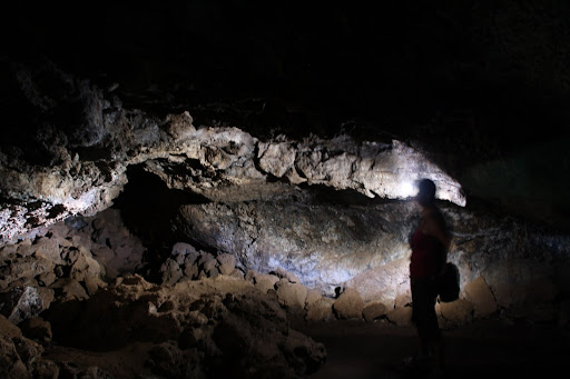 Amy explores the cave with a headlamp