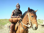 Himba Mann auf seinem Pferd , seine Bettrolle hat er vor sich. Himba Mann auf seinem Pferd , seine Bettrolle hat er vor sich.