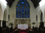 the central Altar and sanctuary with choir pews in foreground. The window shows the Lord Jesus Christ in his infancy and ascended Majesty. The other four figures are St. Matthew, St. Mark, St. Luke & St. John. the central Altar and sanctuary with choir pews in foreground. The window shows the Lord Jesus Christ in his infancy and ascended Majesty. The other four figures are St. Matthew, St. Mark, St. Luke & St. John.