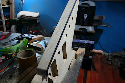 More scraping... A spindle sander was used on the drill press to take off most of the excess plastic binding, particularly around the curved tips of the body wings.