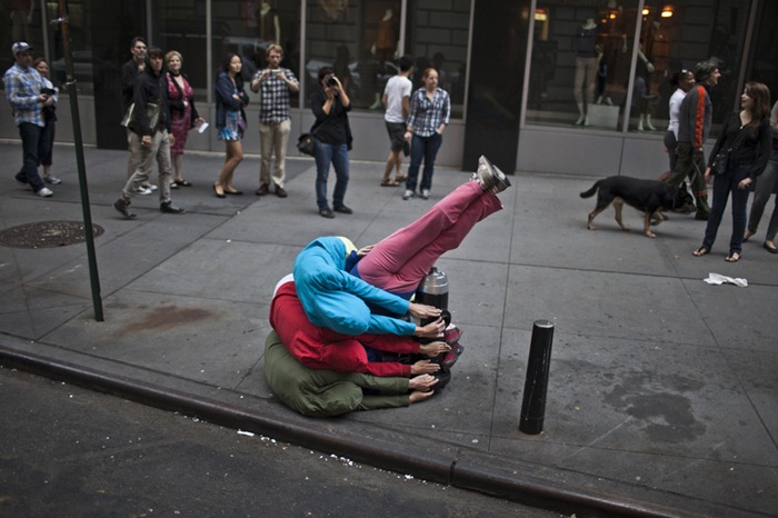 Performers situate themselves into position during a piece entitled "Bodies in Urban Spaces" by choreographer Willi Dorner.  Starting at sunrise, the performers inched their way into different spaces throughout lower Manhattan.CREDIT: Bryan Derballa for The Wall Street JournalNYBODIES