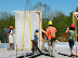Prefabricated straw bale wall panel number 2 is moved into place next to the frame