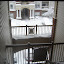 The view down the stairwell towards the front of the building is filled with windswept snow.
