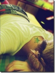 fake deitada com tatoo de estrela no pescoço