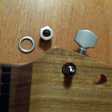 Here's a picture showing the tuner inserted from underneath and the washer and threaded sleeve that go on top.