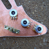 The back of the pickguard with the pots and switch attached.