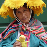 Sad looking Quechuan woman is happy to pose with Duckee in Cusco
