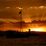 Rays of light lancing through the clouds behind the reed boat