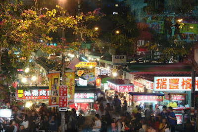 The crowd, and the densely arranged stalls in the market.
