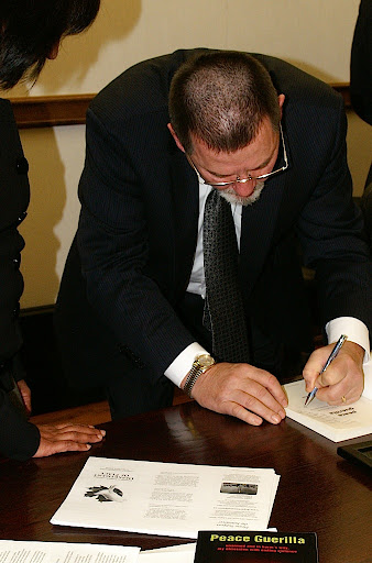 Photo of Ben Hoffman Signing Peace Guerilla Book at the Peace Professionals Event