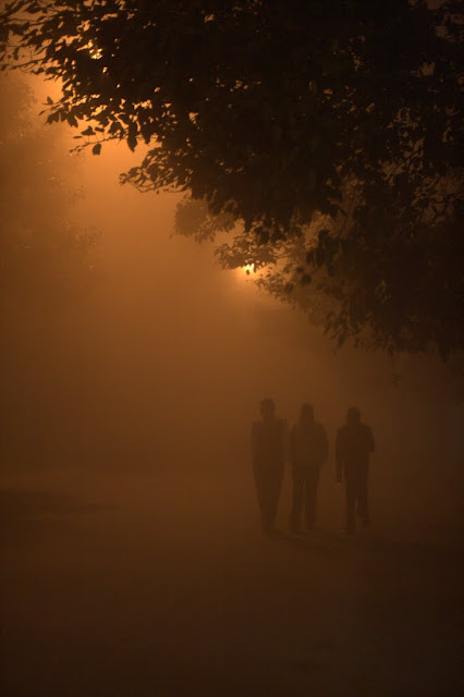 3 men walking in the delhi fog